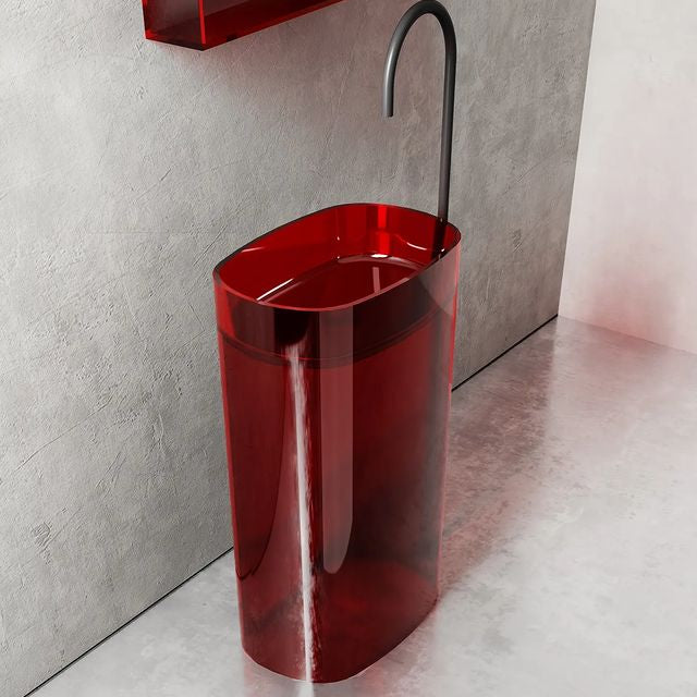 Red freestanding sink with black faucet against a gray wall.