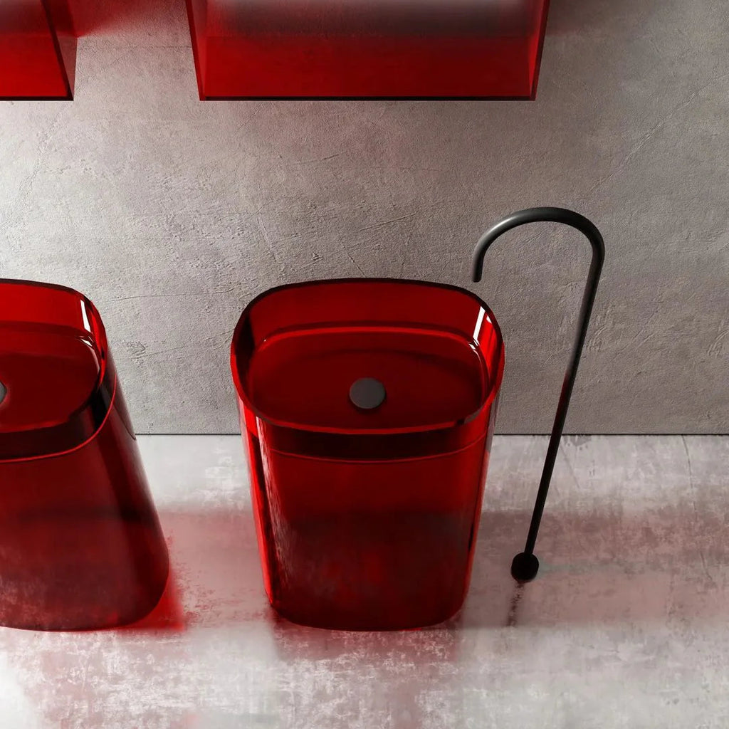 Red sink with black faucet on a gray tiled wall background