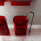 Red sink with black faucet on a gray tiled wall background