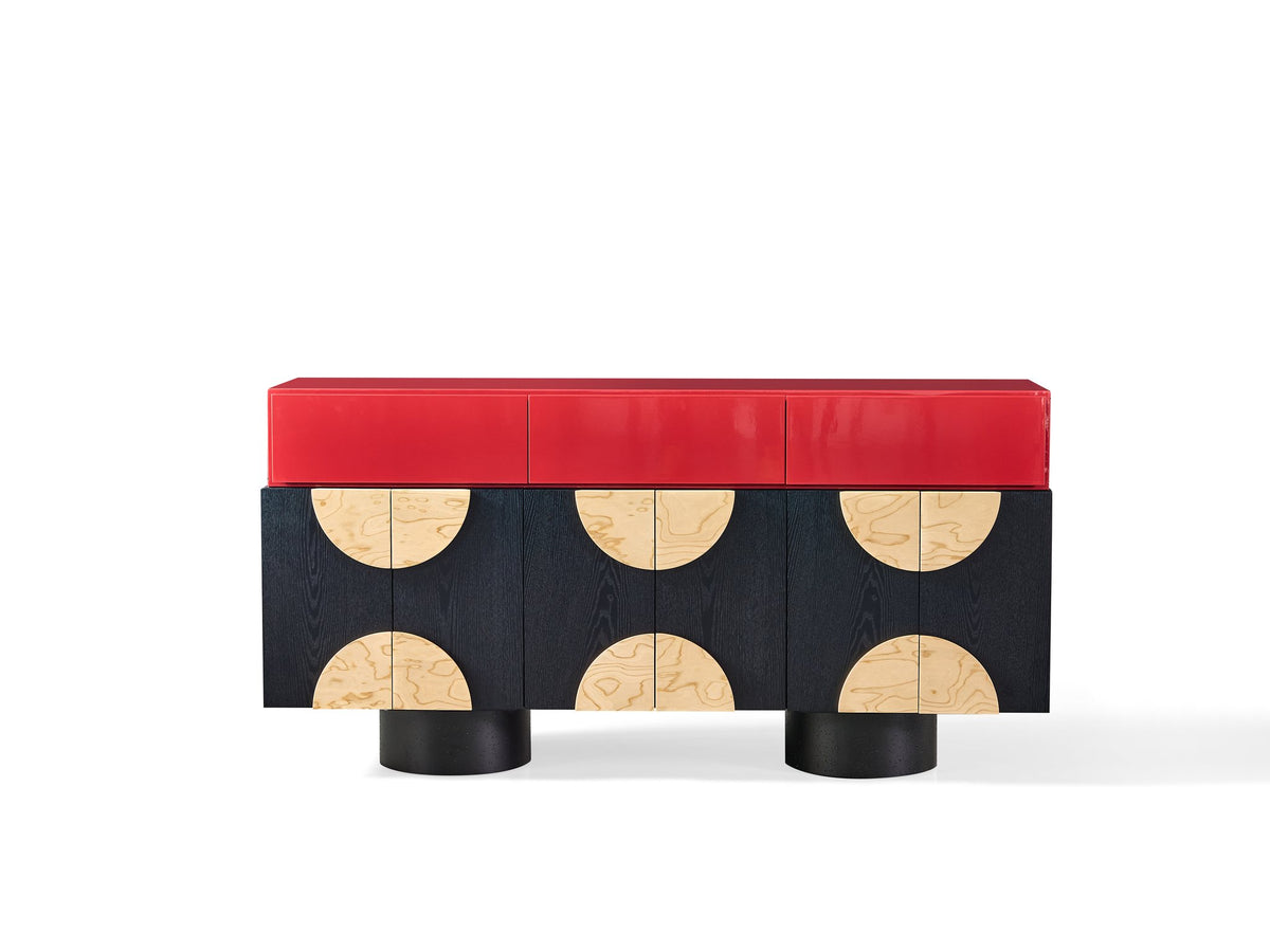 Modern console table with red top and black base with circular designs on a white background