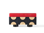 Modern console table with red top and black base with circular designs on a white background