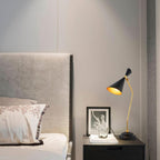Modern bedroom with a bed, nightstand, and decorative lamp.
