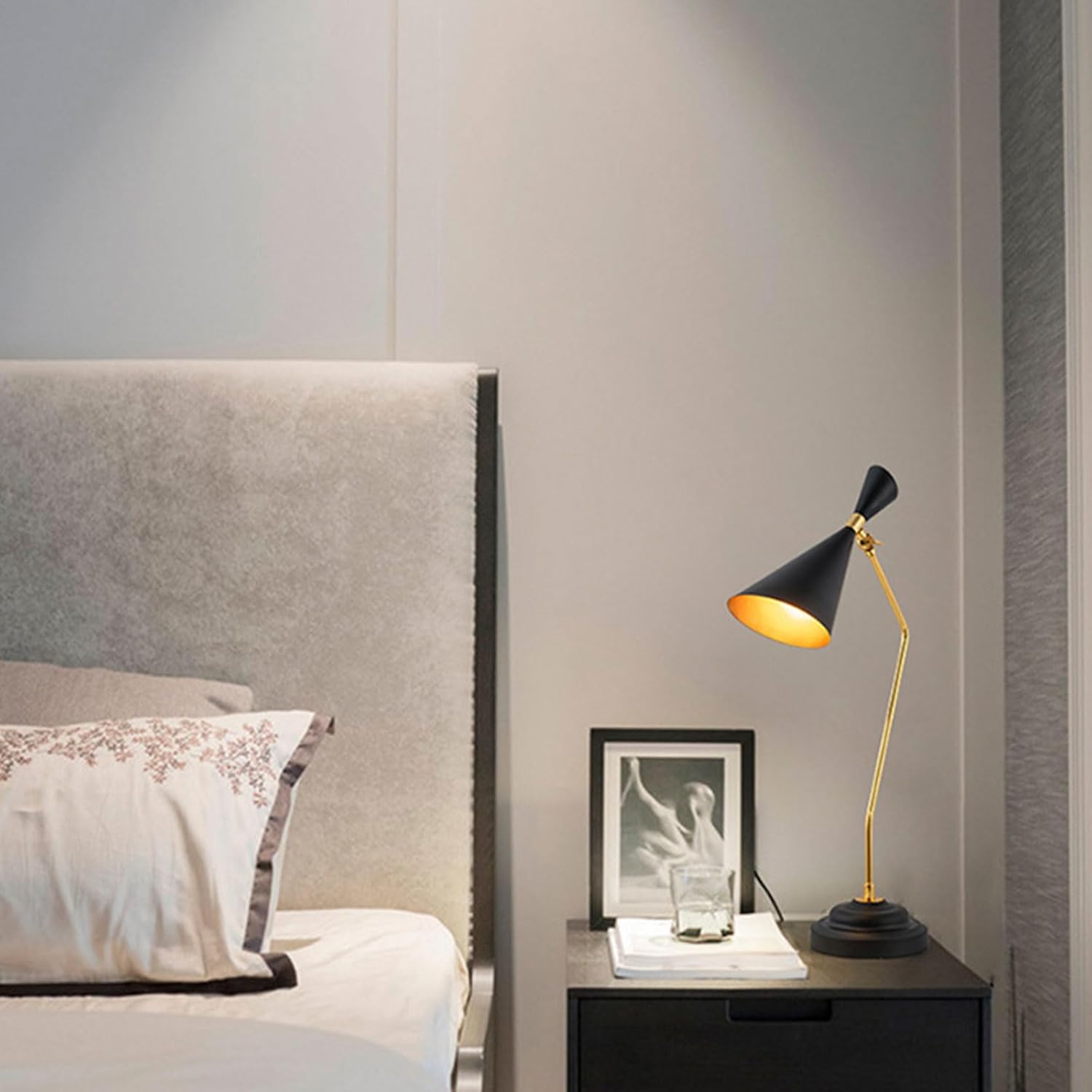 Modern bedroom with a bed, nightstand, and decorative lamp.