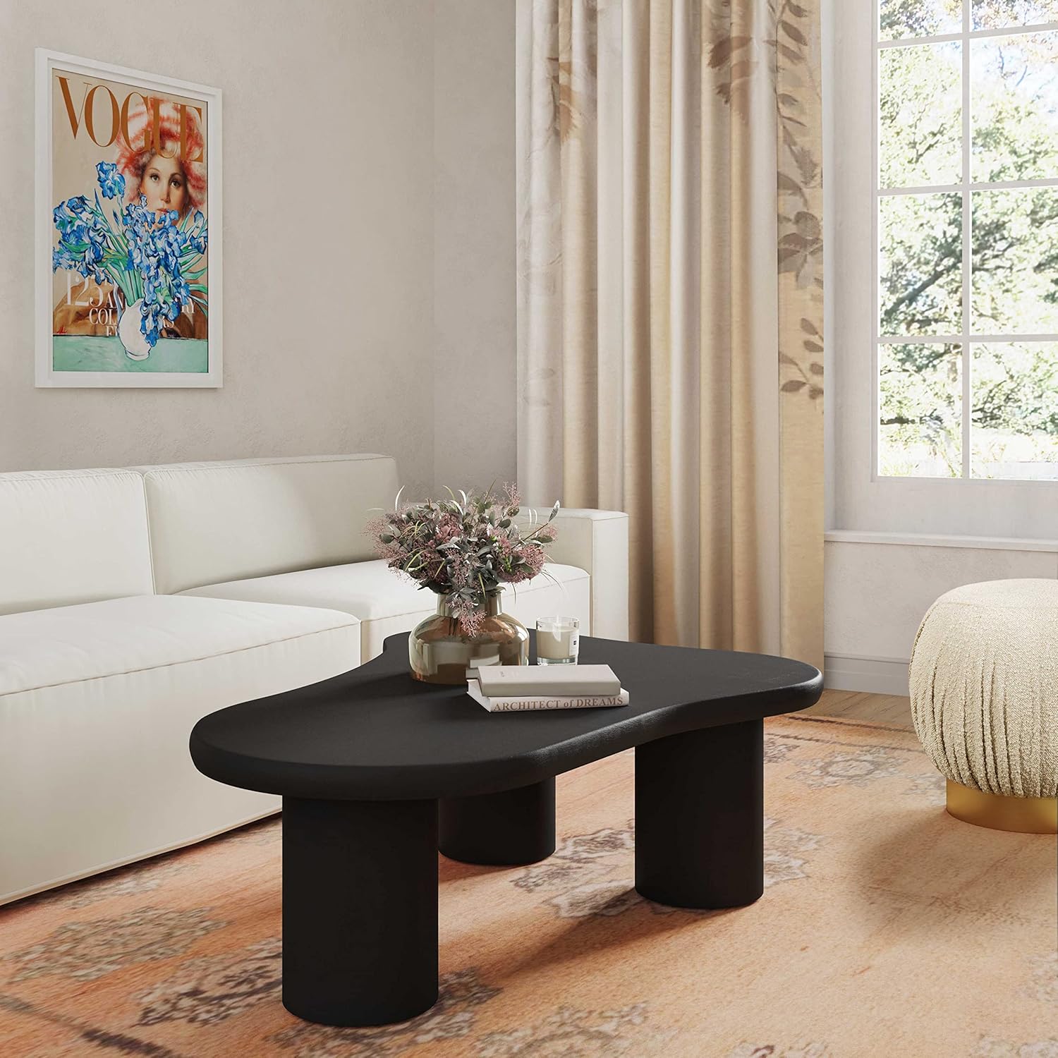 Modern living room with a black coffee table, white sofa, and decorative elements.