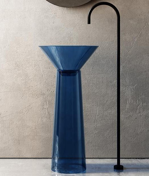 Blue glass vase with a black curved faucet against a beige wall.
