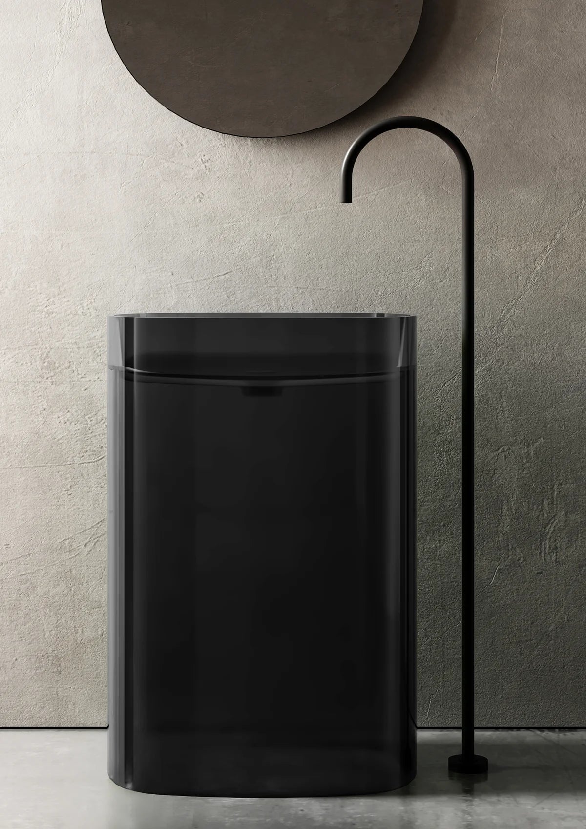 Black freestanding sink against a textured wall with a decorative metal fixture.