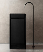 Black freestanding bathtub with a modern faucet against a neutral wall.