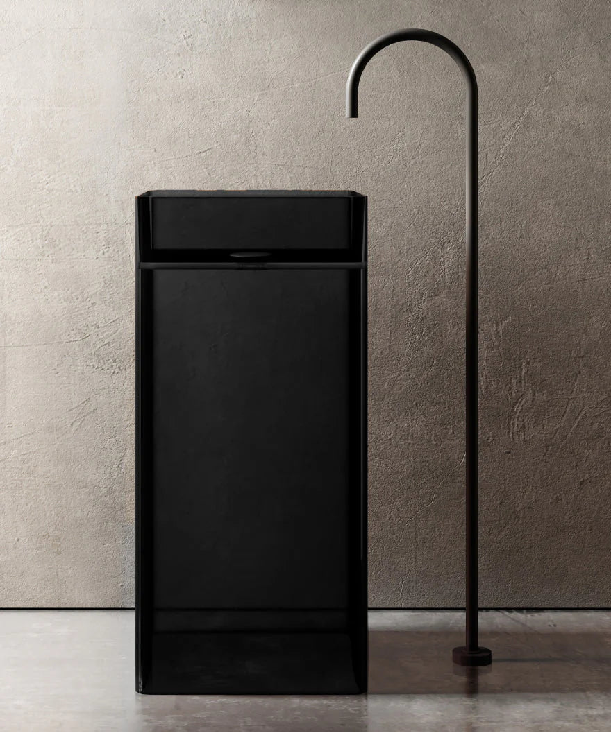 Black freestanding bathtub with a modern faucet against a neutral wall.