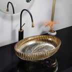 Gold sink basin with black faucet in a bathroom setting