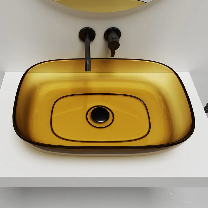 Yellow glass sink with black faucet on a white countertop